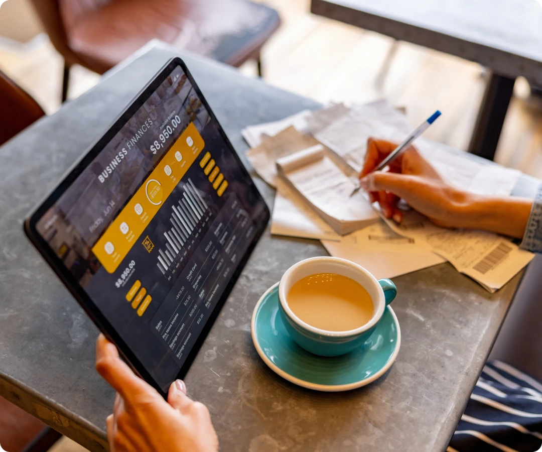Tablet with financial data next to coffee.
