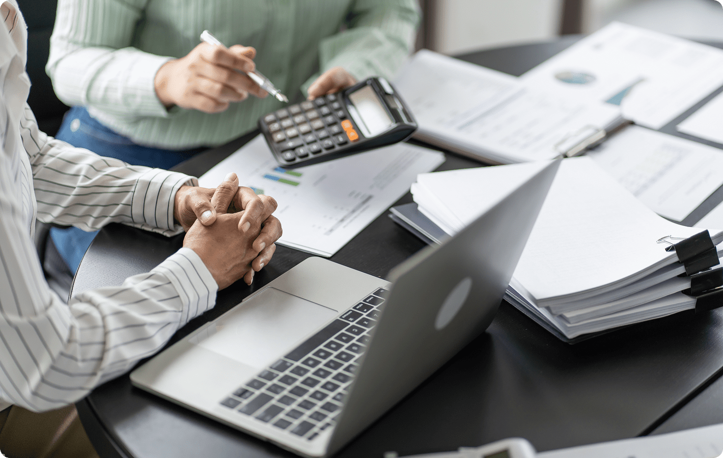 People working with laptop and calculator.